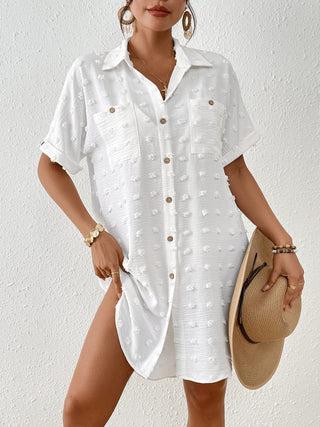A woman wearing a Swiss dot beach shirt dress with short sleeves.