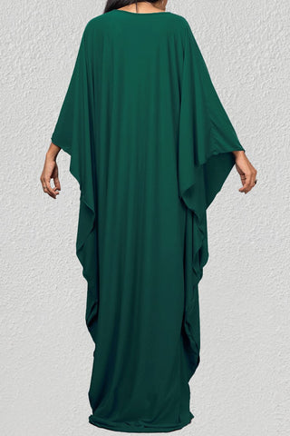 A woman wearing a green beach cover kaftan dress.