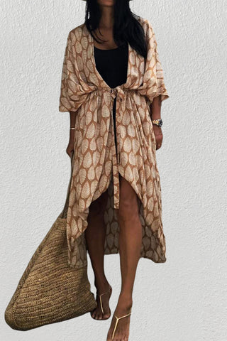 A woman wearing a black leaf kimono cardigan with a bag.