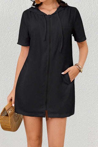 A woman wearing a black zipper hooded swimsuit coverup.
