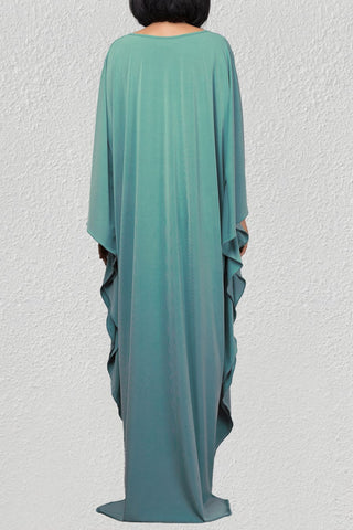 A woman wearing a green maxi skirt caftan cover up.