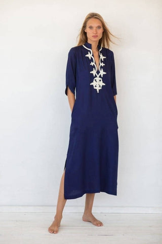 A woman wearing a blue V-neck kaftan maxi dress.