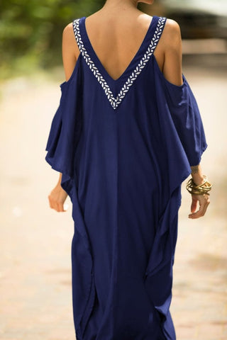 A woman wearing a dark blue long kaftan dress.