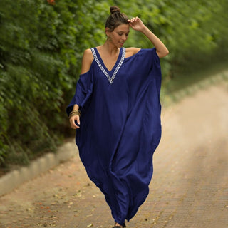 A woman wearing a dark blue v-neck kaftan dress.
