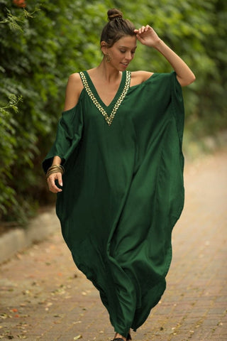 A woman wearing a green v-neck plus size kaftan dress.