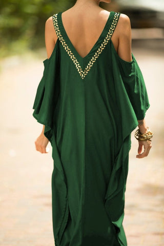 A woman wearing a long green v-neck kaftan dress.