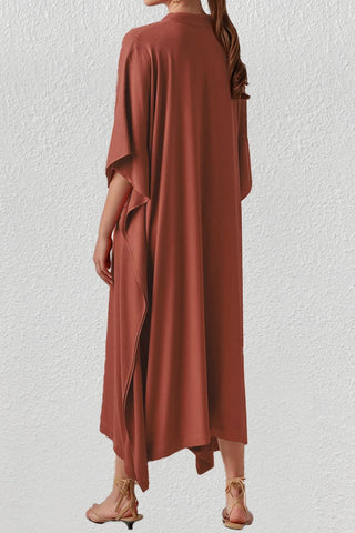 A woman wearing a red v-neck beach kaftan dress.